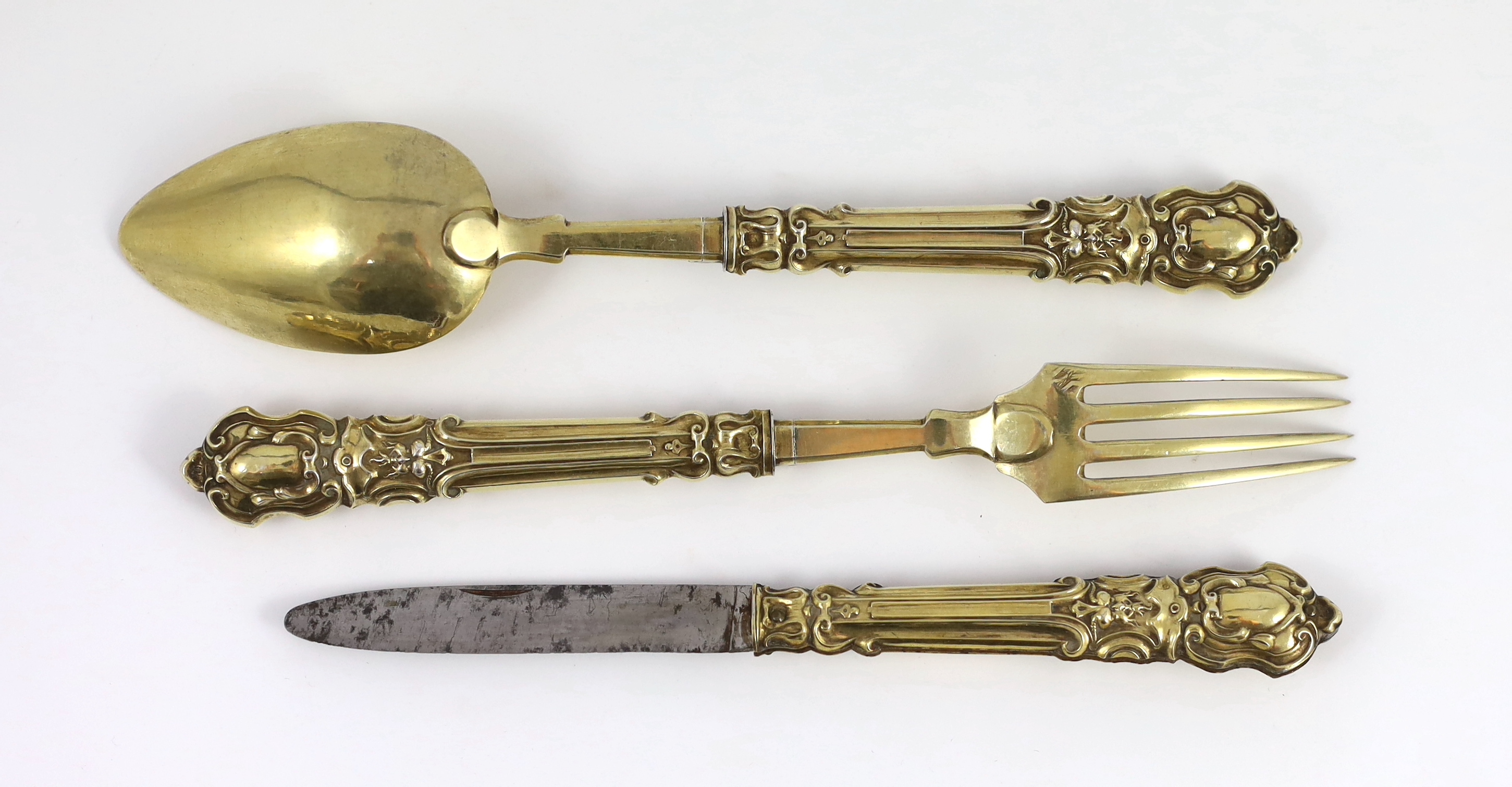 A 19th century French silver gilt three piece folding cutlery set with mascaroon green man decoration